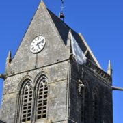 D-day Saint Mere Eglise, il parà sul tetto della chiesa e la vetrata artistica che ricorda l