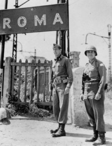 Il generale Mark Clark sotto al cartello di ingresso a Roma (foto National Archives)