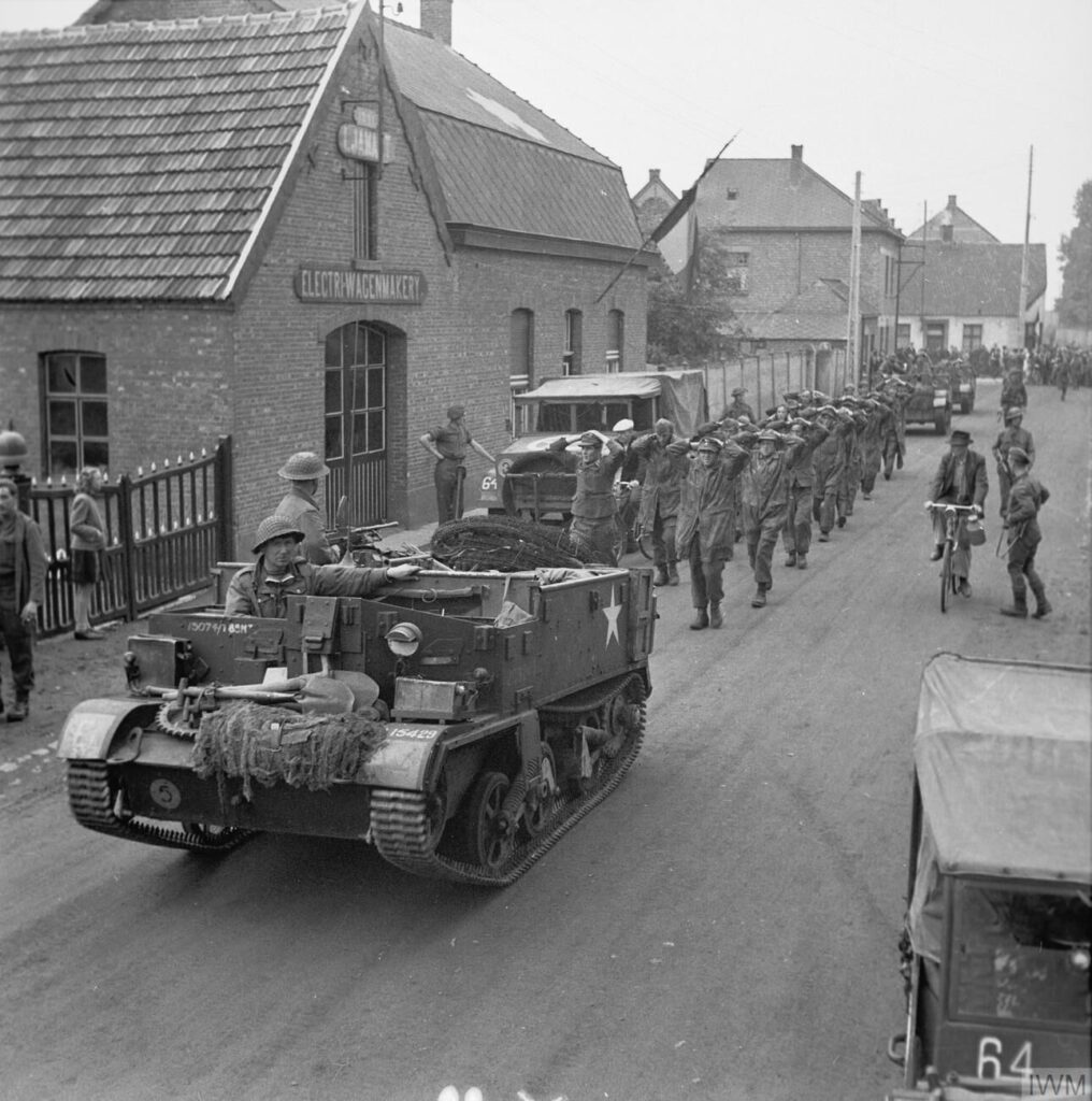 Un Bren Gun Carrier con soldati britannici e contrassegni statunitensi scorta una colonna di prigionieri tedeschi (IWM)